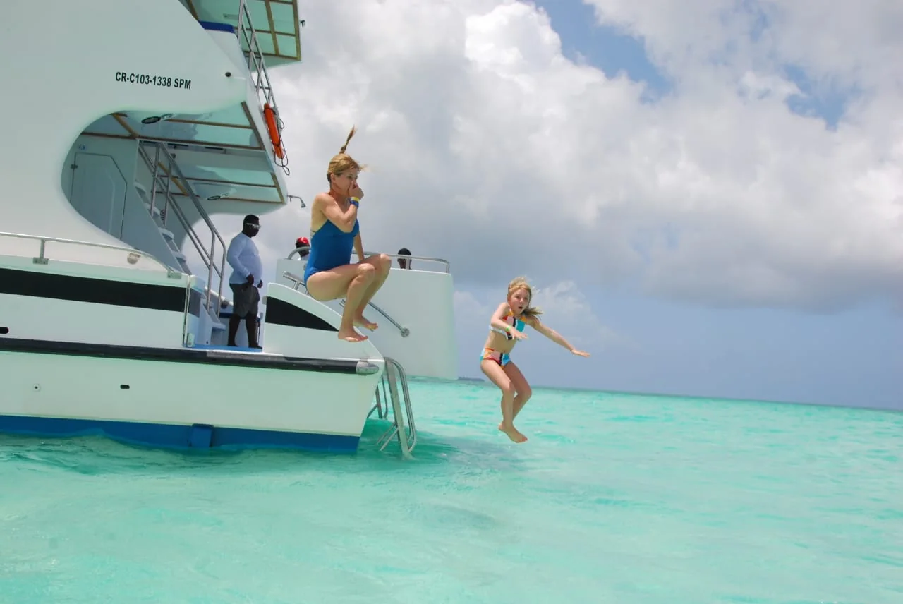Guests jumping from a private catamaran into the clear Saona Island Natural Pool
