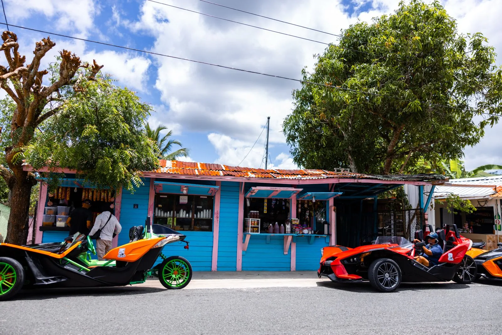Polaris Slingshots parked beside a colorful local Dominican village shop