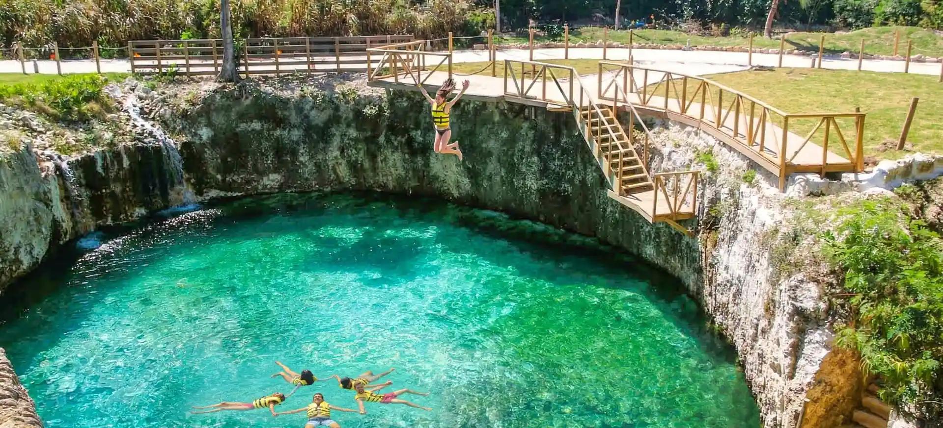 Guests swimming and jumping into a natural cenote at El Dorado Park Punta Cana.