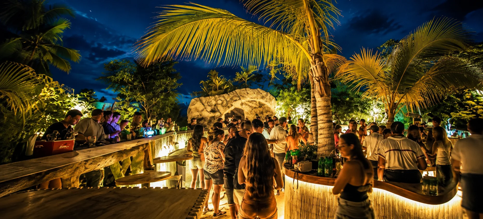 Guests enjoying the tropical outdoor night bar at Domitai Park in Punta Cana.