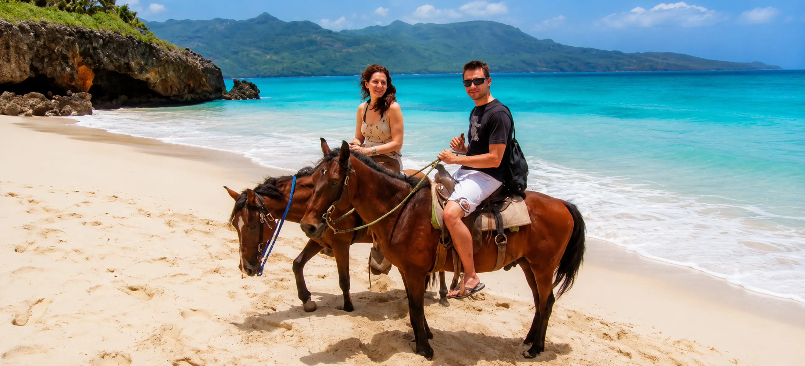 Couple horseback riding on a tropical beach during a Punta Cana excursion
